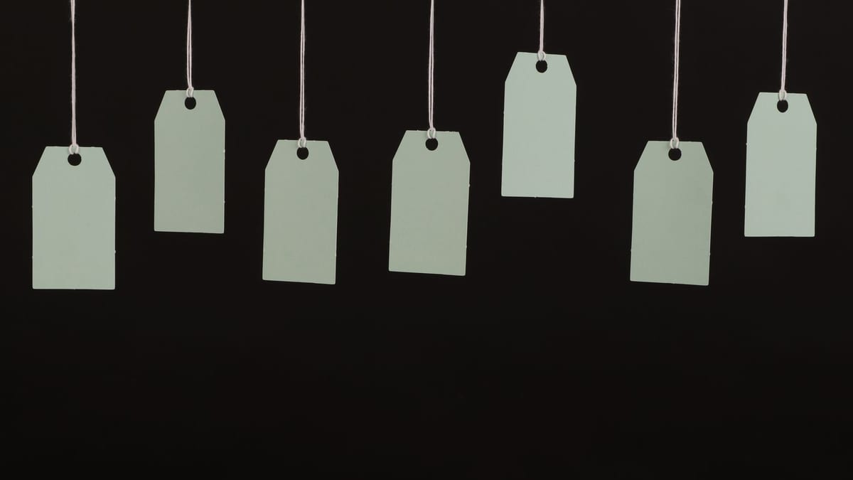 Blank hang tags on strings against a dark background