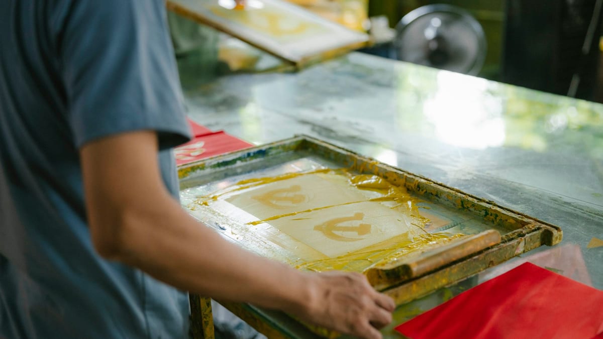 Screen printing frame with yellow ink on a printing table